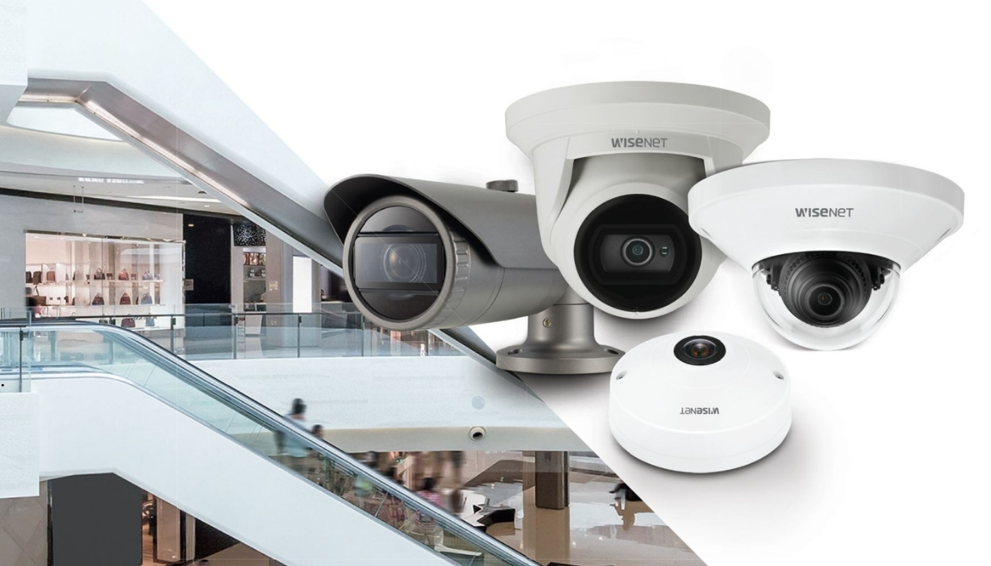 Introduction The Evolution of Smart Surveillance Modern security professional monitoring multiple network camera feeds on large screens, representing Hanwha Vision’s advanced smart surveillance technology.